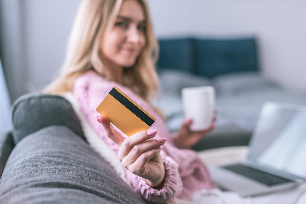foco seletivo de cartão de crédito em mãos de mulher loira segurando copo com bebida
 - Foto, Imagem