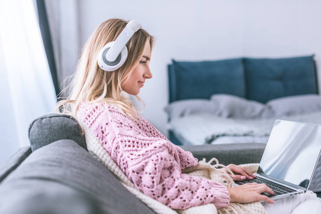 vonzó nő fejhallgató használ a laptop otthon  - Fotó, kép