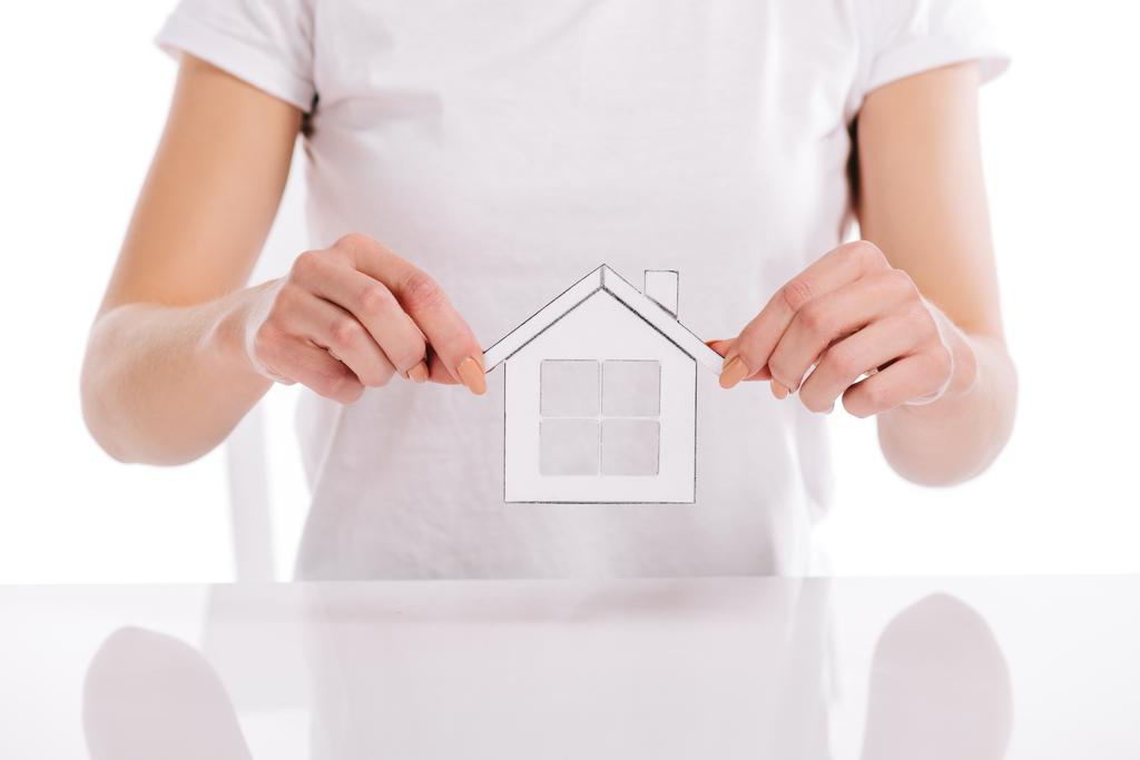 visão parcial da mulher segurando casa de papel isolado em branco, conceito de hipoteca
 - Foto, Imagem