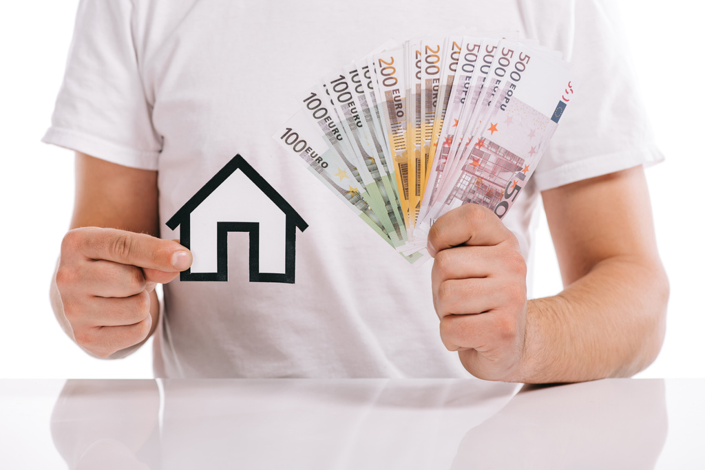 cropped view of man holding cash and paper house isolated on white, mortgage concept - Photo, Image