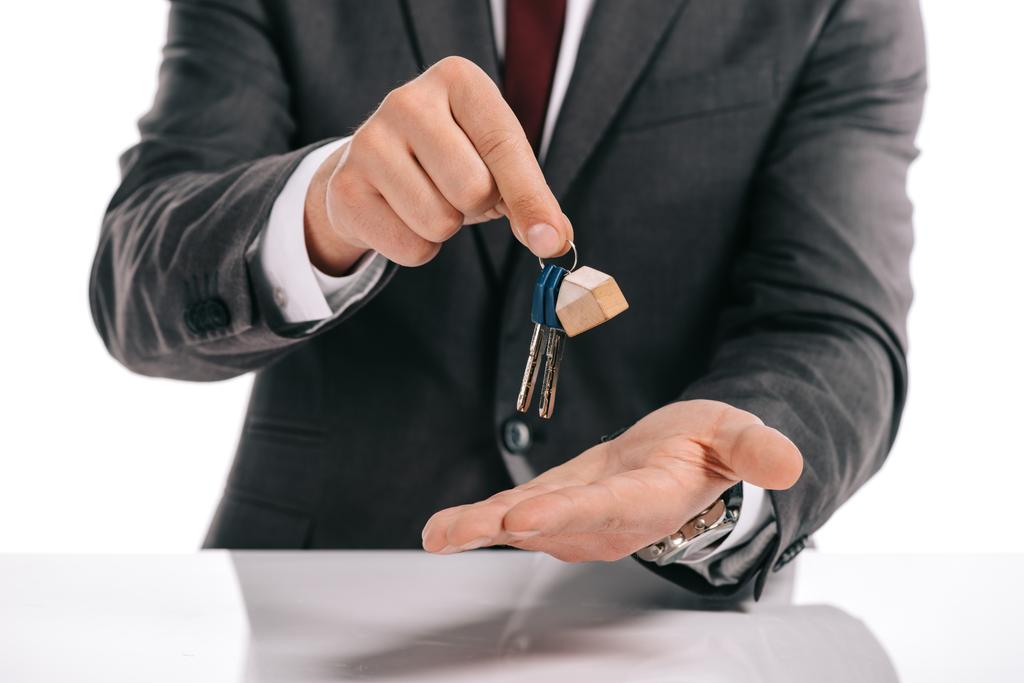 частичный взгляд ипотечного брокера с ключами, изолированными на белом
 - Фото, изображение