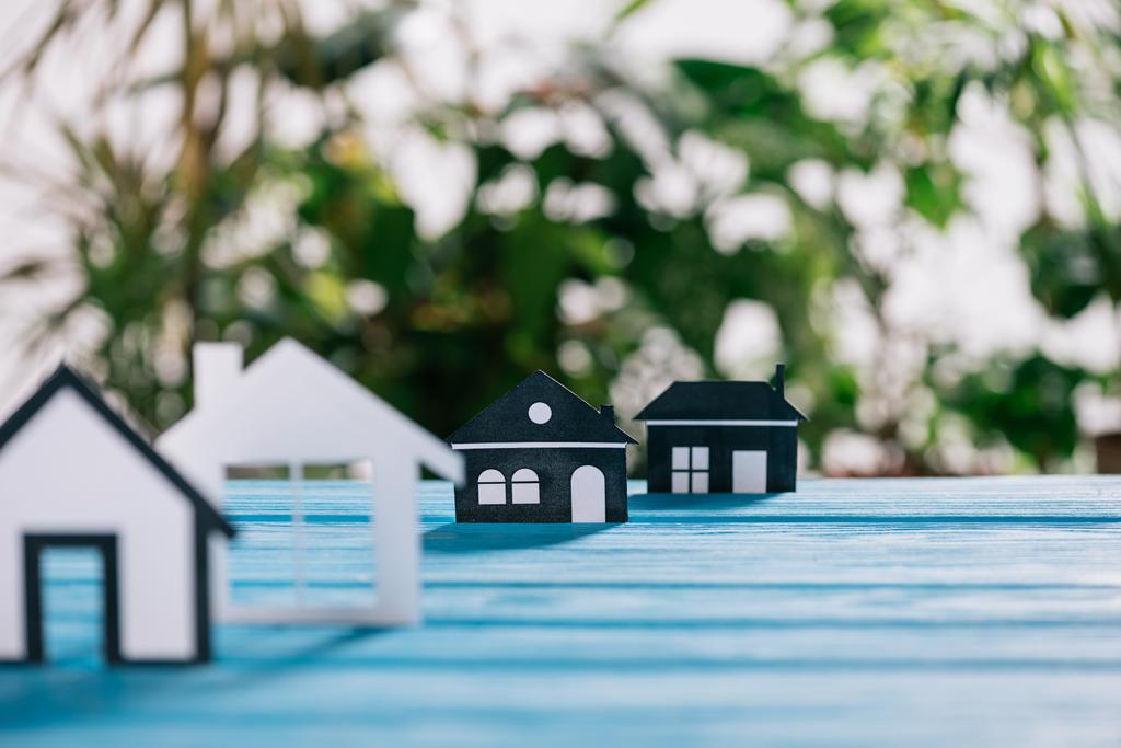 селективное фокусирование бумажных домов на синем деревянном столе, концепция ипотеки
 - Фото, изображение