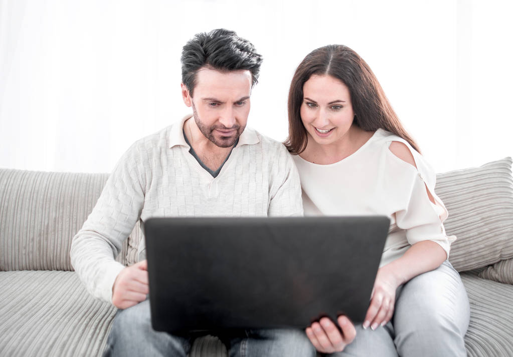 pareja riendo mirando la pantalla del ordenador portátil
. - Foto, Imagen