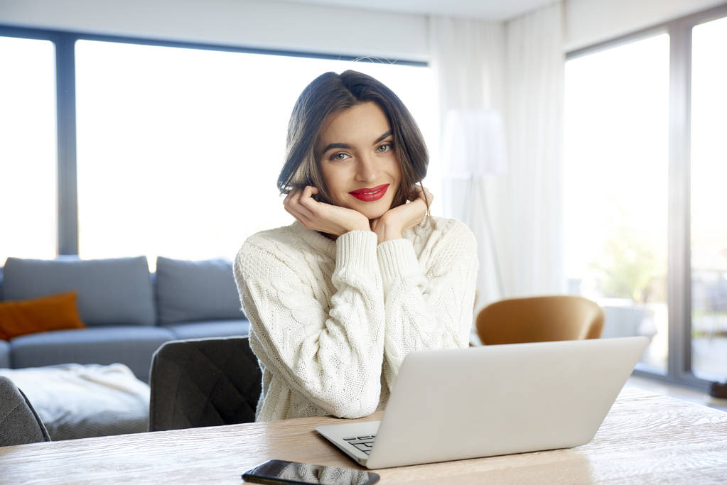Знімок красивої молодої жінки, використовуючи свій ноутбук, сидячи за столом і навчаючись вдома
. - Фото, зображення