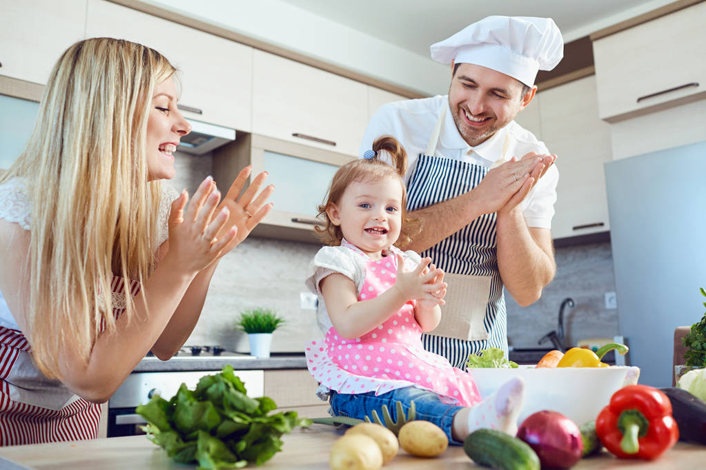 Una famiglia prepara cibo dalle verdure in cucina
. - Foto, immagini