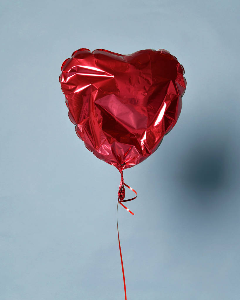 Κόμμα είναι πάνω αποπληθωρισμένο κόκκινο μπαλόνι αντικειμένου για το πάρτι γενεθλίων της καρδιάς, ή αγάπη του Αγίου Βαλεντίνου - Φωτογραφία, εικόνα