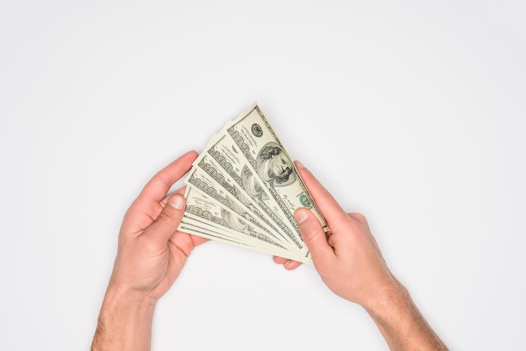 Teilansicht eines Mannes, der Geld in Händen hält, isoliert auf grau - Foto, Bild