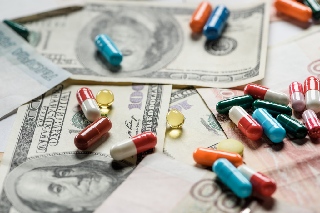 крупним планом різнокольорові таблетки на грошовому фоні
 - Фото, зображення