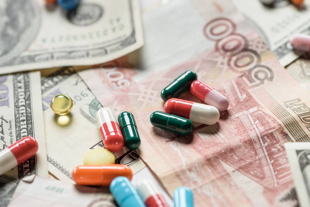 Nahaufnahme heller unterschiedlicher Pillen auf Geldhintergrund - Foto, Bild