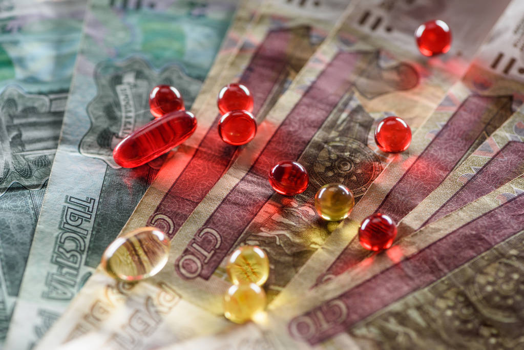 Close up van heldere ovale en ronde pillen op contant geld achtergrond - Foto, afbeelding
