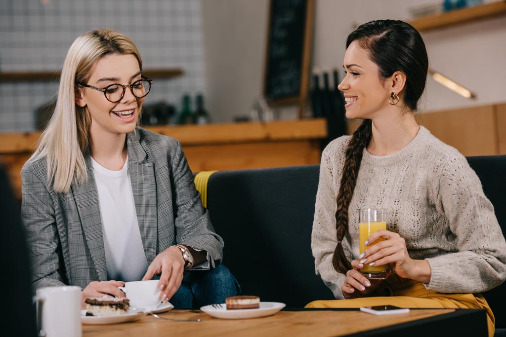 attractive friends chatting in cafe with drinks - Photo, Image