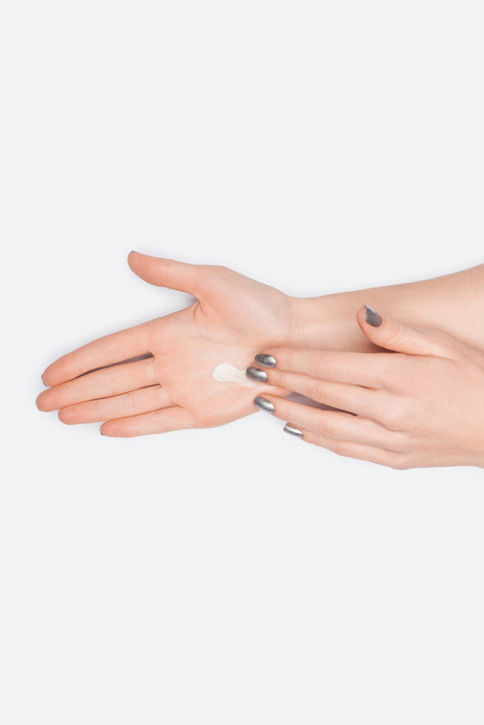 vista parziale della donna che applica la crema per le mani isolata sul bianco
 - Foto, immagini