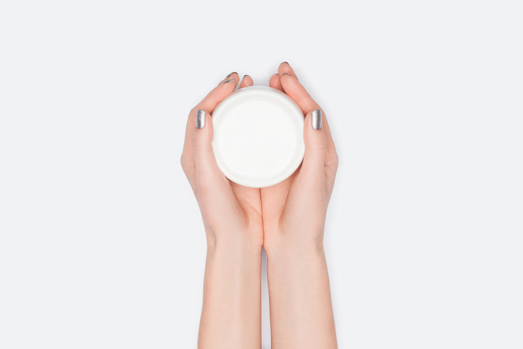 vista recortada de la mujer sosteniendo crema de manos aislado en blanco
 - Foto, Imagen