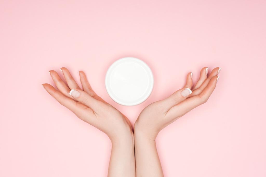 cropped view of female hands with body cream isolated on pink - Photo, Image