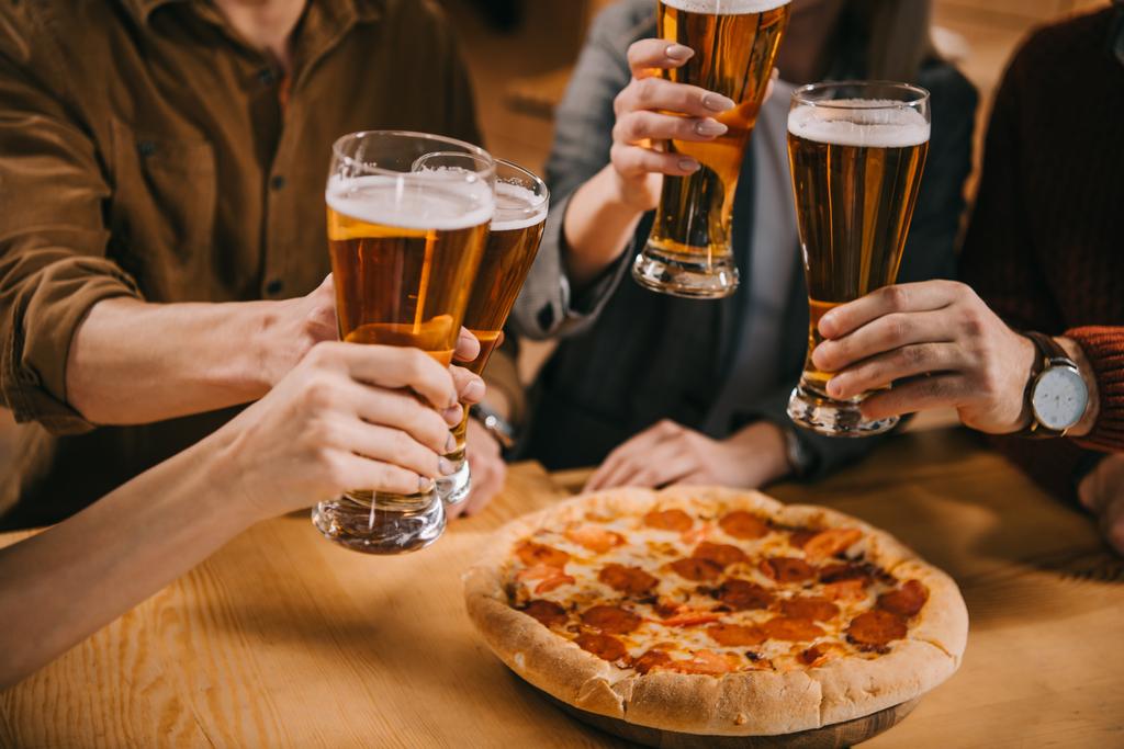 обрезанный вид друзей тост бокалы пива в баре
 - Фото, изображение