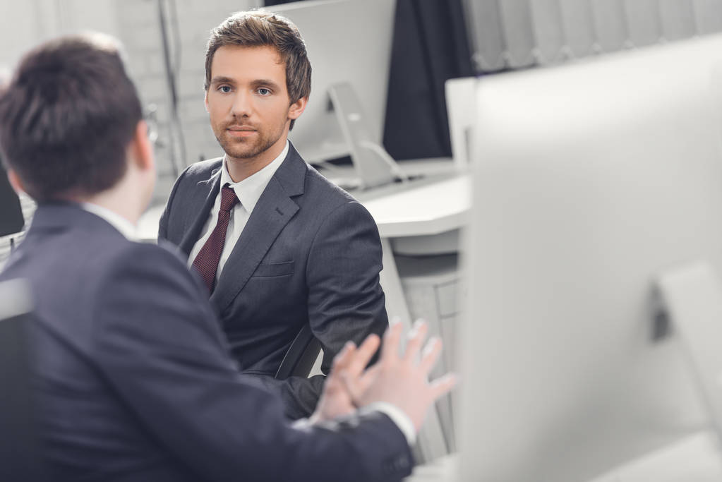 enfoque selectivo de los hombres de negocios hablando mientras trabajan juntos en la oficina
 - Foto, imagen