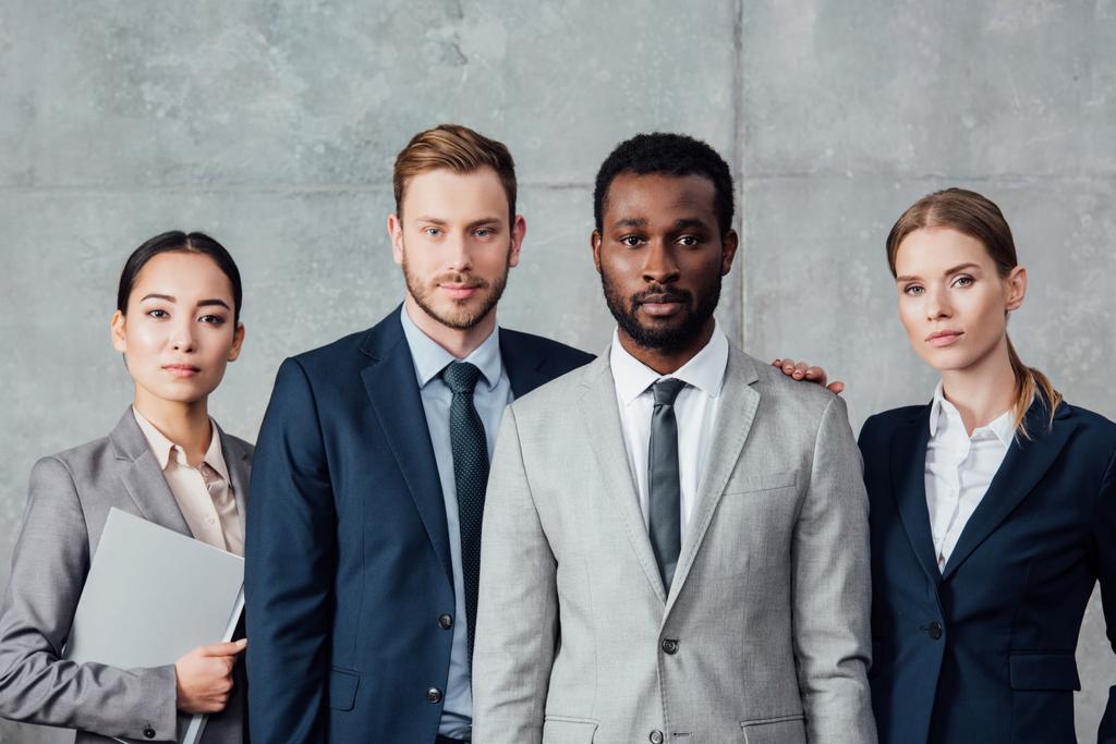 grupo multiétnico grave de empresários em vestuário formal posando e olhando para a câmera
 - Foto, Imagem