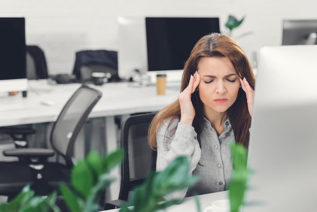 молодая предпринимательница, страдающая головной болью во время работы в офисе
  - Фото, изображение