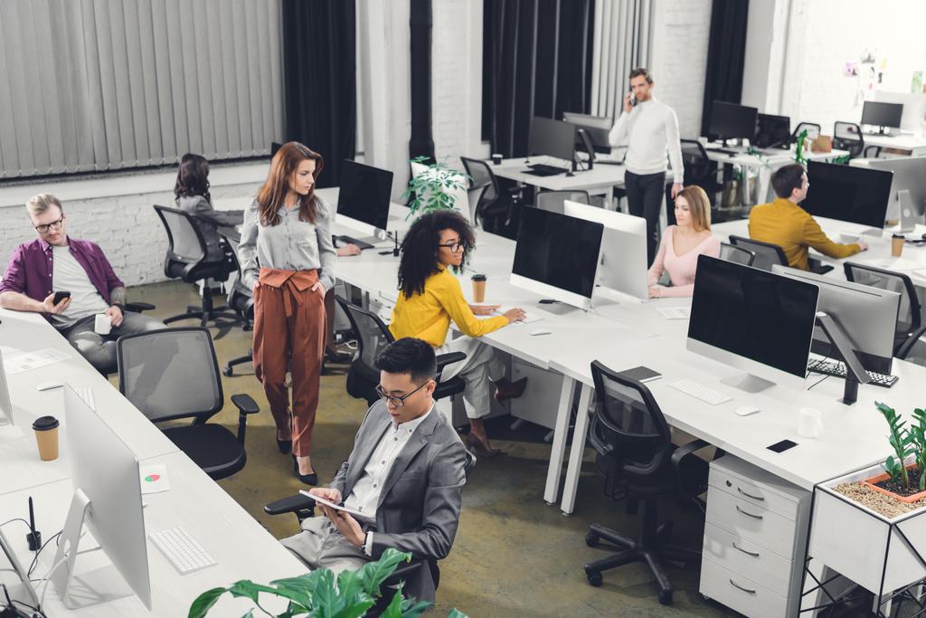 visão de alto ângulo de profissionais jovens empresários multiétnicos que trabalham em escritório de espaço aberto
 - Foto, Imagem