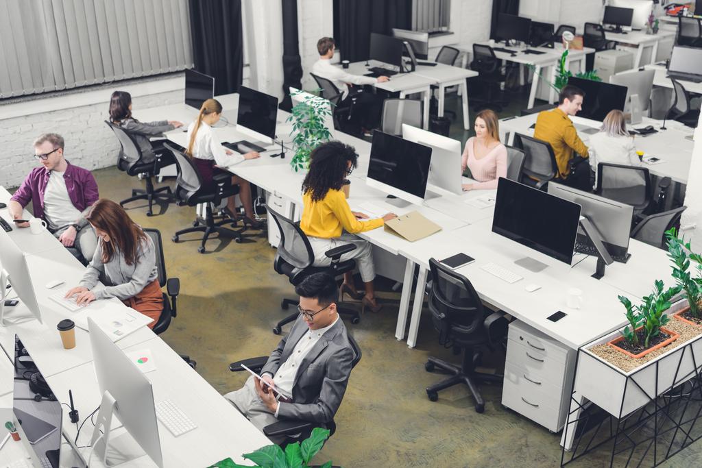 hoge hoekmening van jonge multi-etnische ondernemers werken in open ruimte kantoor - Foto, afbeelding