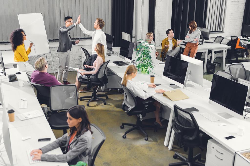 hoge hoekmening van professionele multiraciale ondernemers werken samen in open ruimte kantoor  - Foto, afbeelding