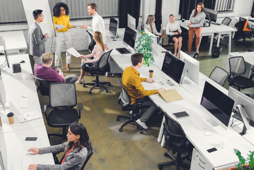 visão de alto ângulo de profissionais jovens colegas de negócios que trabalham juntos no escritório de espaço aberto
     - Foto, Imagem