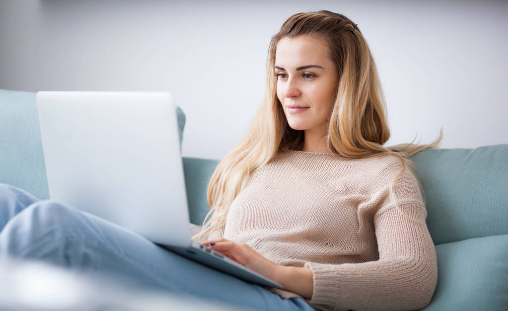 Mulher feliz em casa usando laptop sentado no sofá, online trabalhando em casa - Foto, Imagem