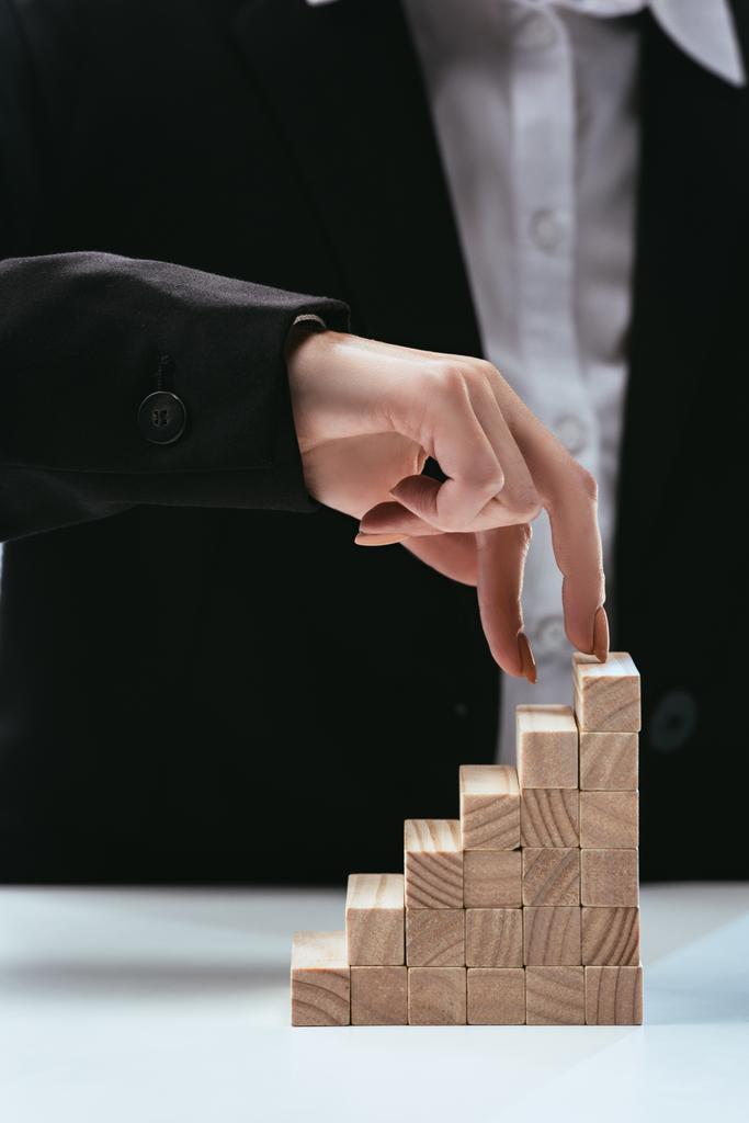 cropped view of woman walking with fingers on wooden blocks symbolizing career ladder - Photo, Image
