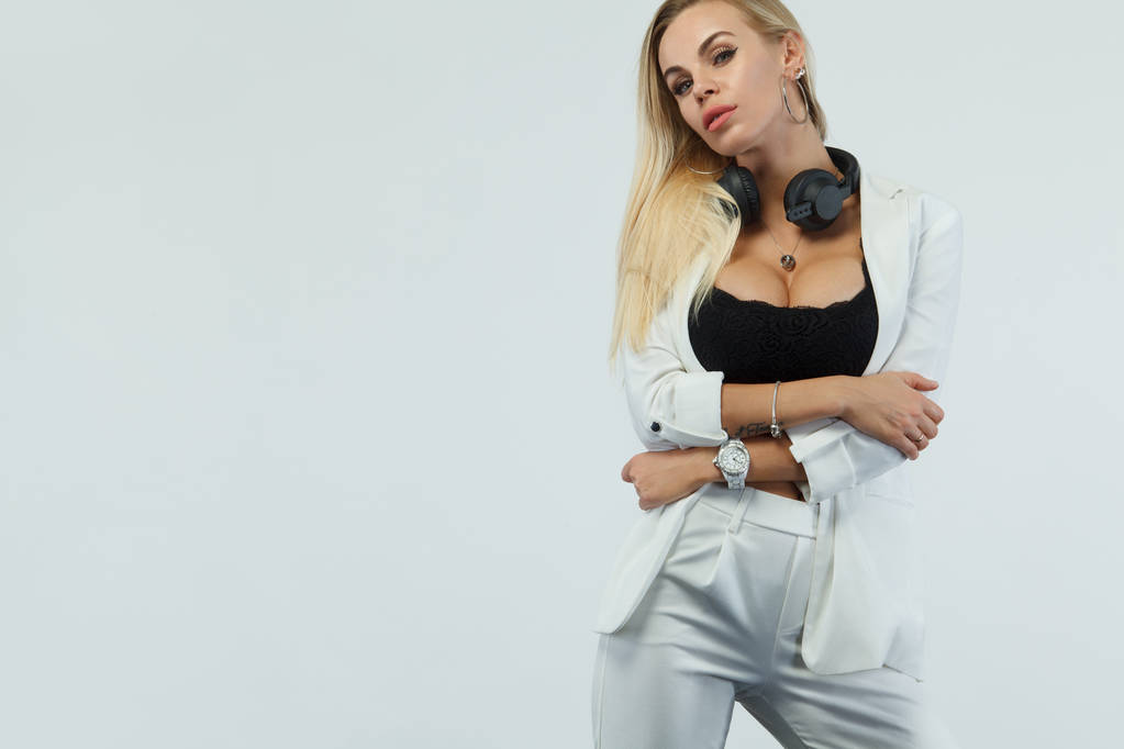 schöne sexy blonde dj Frau auf weißem Hintergrund im Studio trägt Kopfhörer. - Foto, Bild