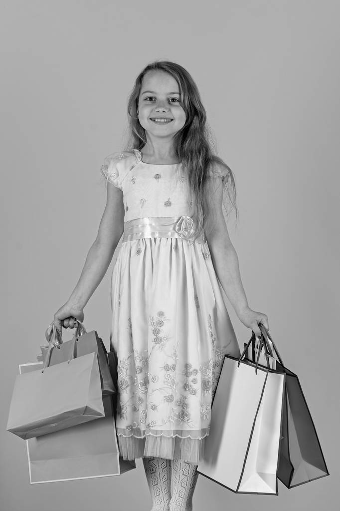 Κορίτσι με το χαρούμενο πρόσωπο κατέχει τσάντες για ψώνια σε ροζ φόντο - Φωτογραφία, εικόνα