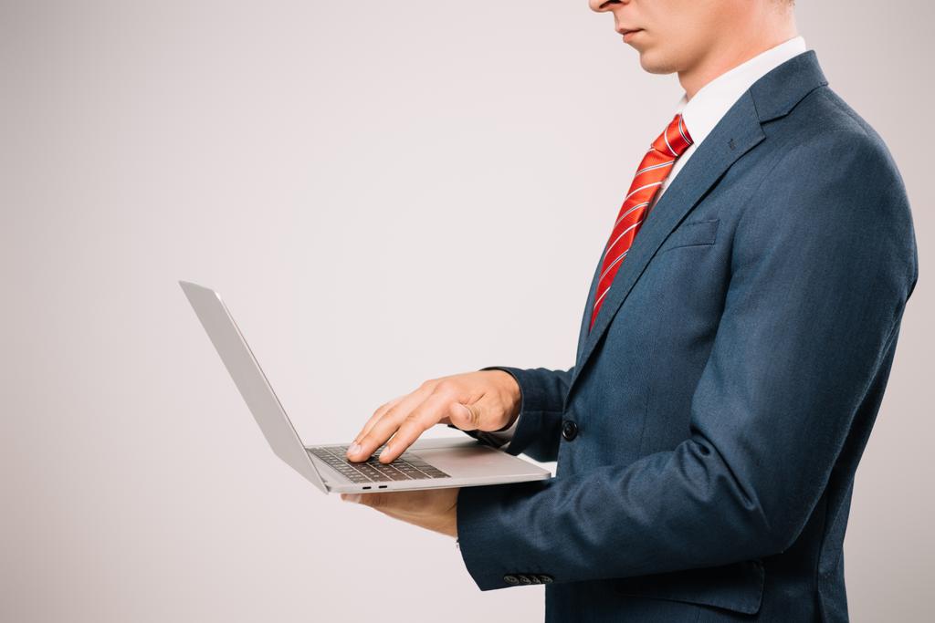 обрізаний вид бізнесмена в костюмі з використанням ноутбука ізольовано на сірому
 - Фото, зображення