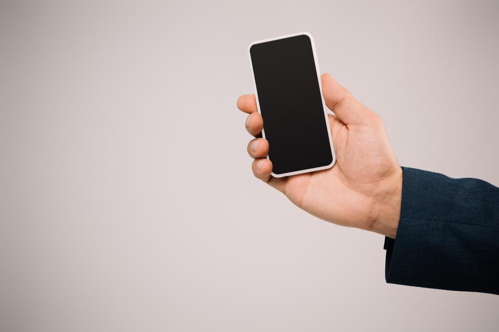 rajattu näkymä liikemies tilalla älypuhelin tyhjä näyttö eristetty harmaa
 - Valokuva, kuva