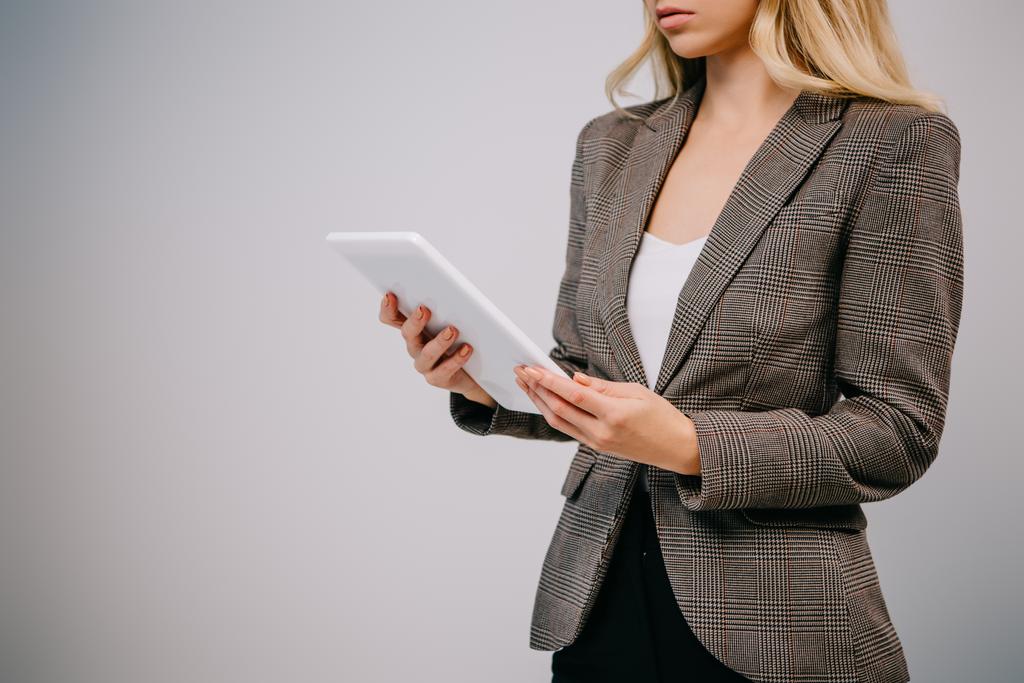 обрізаний вид на бізнес-леді в костюмі з використанням планшета ізольовано на сірому
 - Фото, зображення