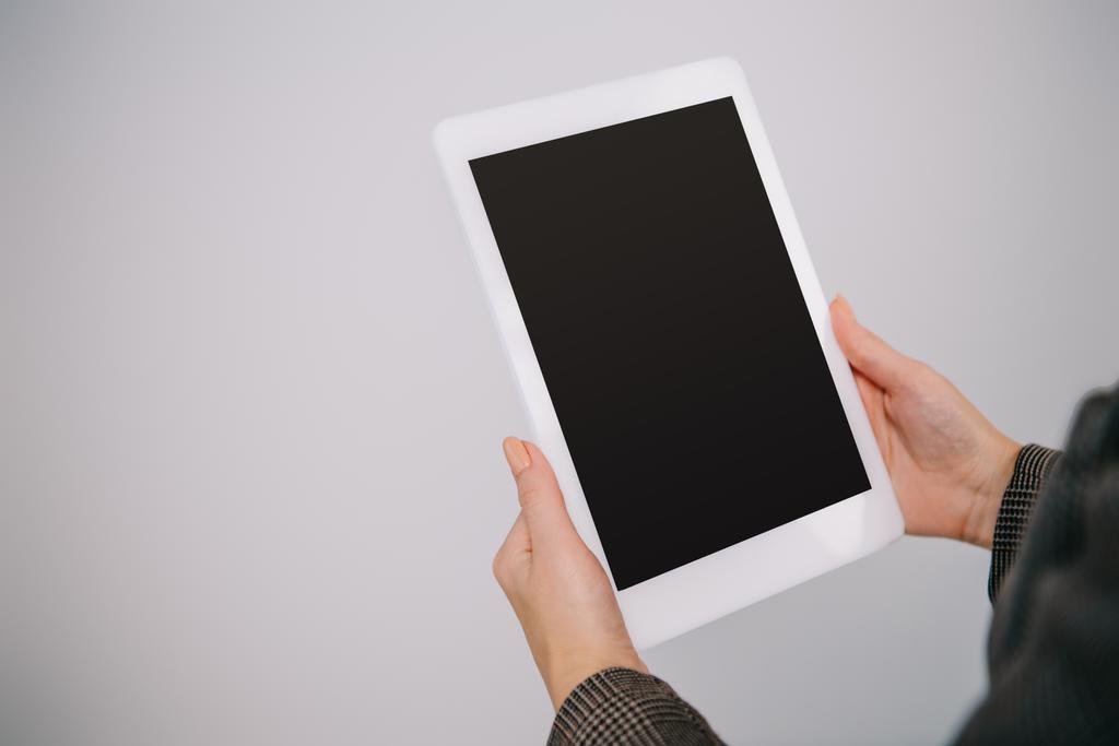 cropped view on businesswoman using digital tablet with blank screen isolated on grey - Photo, Image