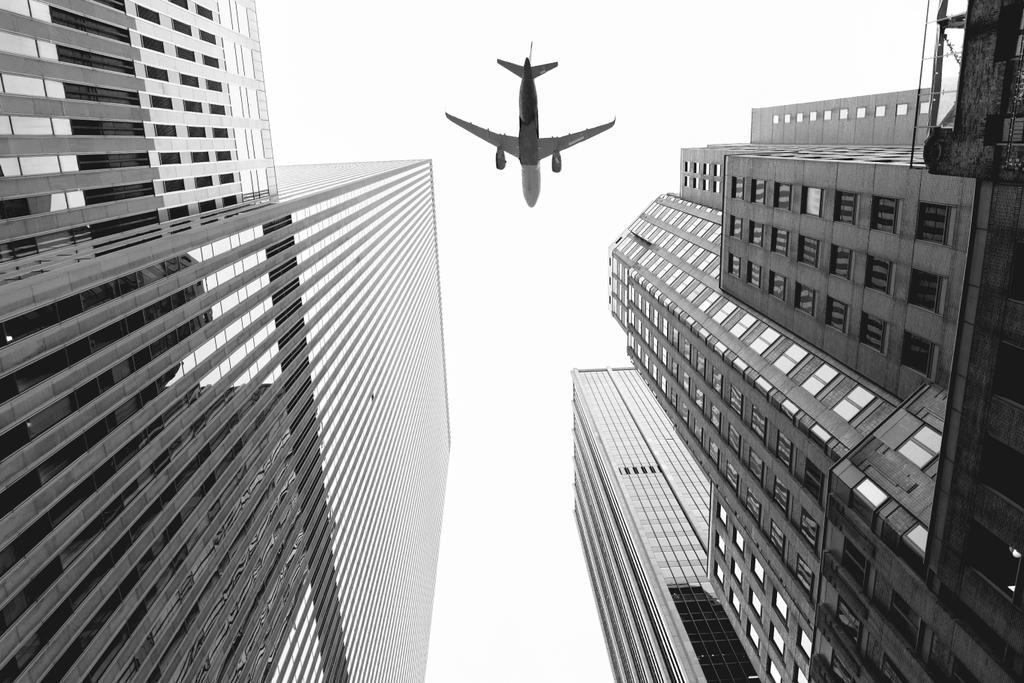 Onderaanzicht van wolkenkrabbers en vliegtuig in de lucht in new york city, Verenigde Staten - Foto, afbeelding
