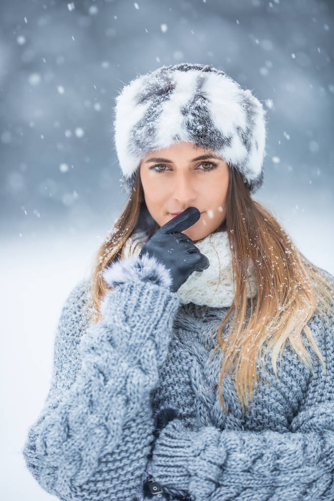 Retrato de mujer joven y hermosa en ropa de invierno y fuerte nevada
. - Foto, imagen