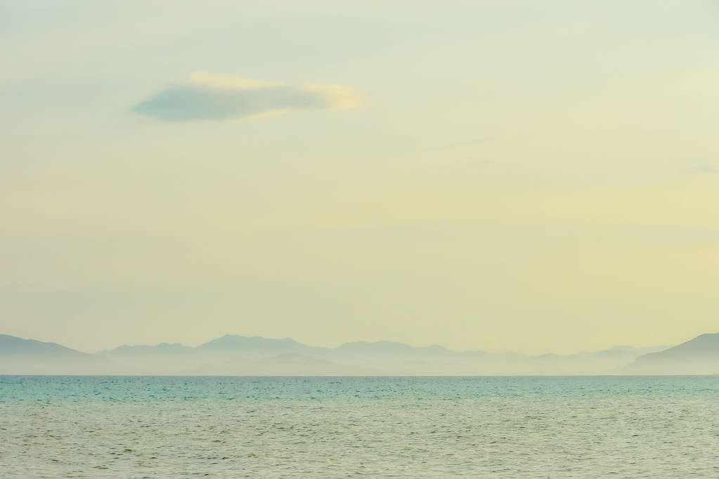 όμορφη γραμμή της θάλασσας και το γαλάζιο ουρανό. επιβλητικά βουνά στην ομίχλη - Φωτογραφία, εικόνα