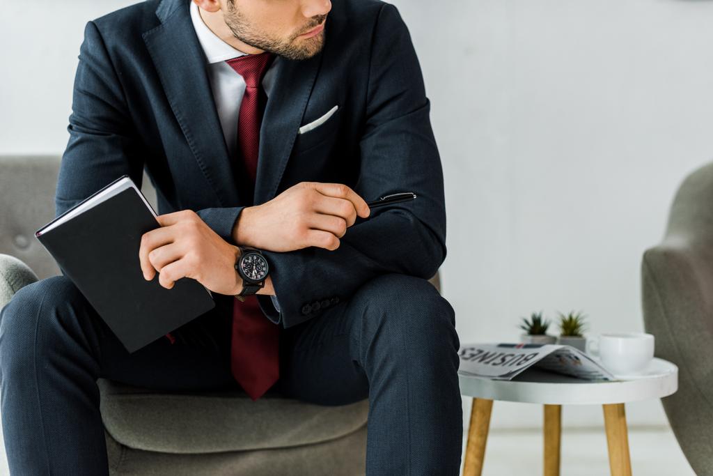 ofiste oturan defter ile formal giyim işadamı görünümünü kırpılmış - Fotoğraf, Görsel
