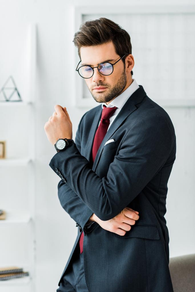 serio hombre de negocios guapo en ropa formal y gafas en la oficina
 - Foto, imagen