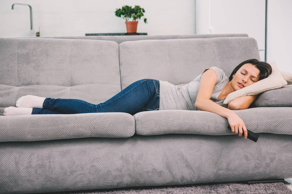 Красива молода жінка спить на дивані
. - Фото, зображення