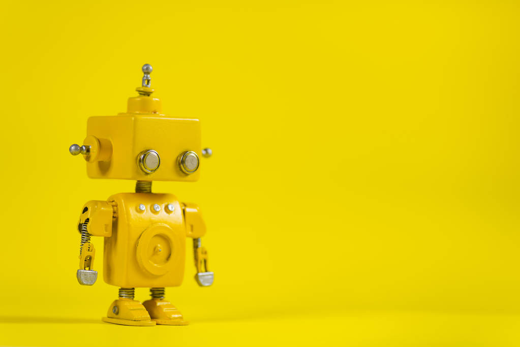 Ładniutka, żółty, ręcznie robione robota na żółtym tle. - Zdjęcie, obraz