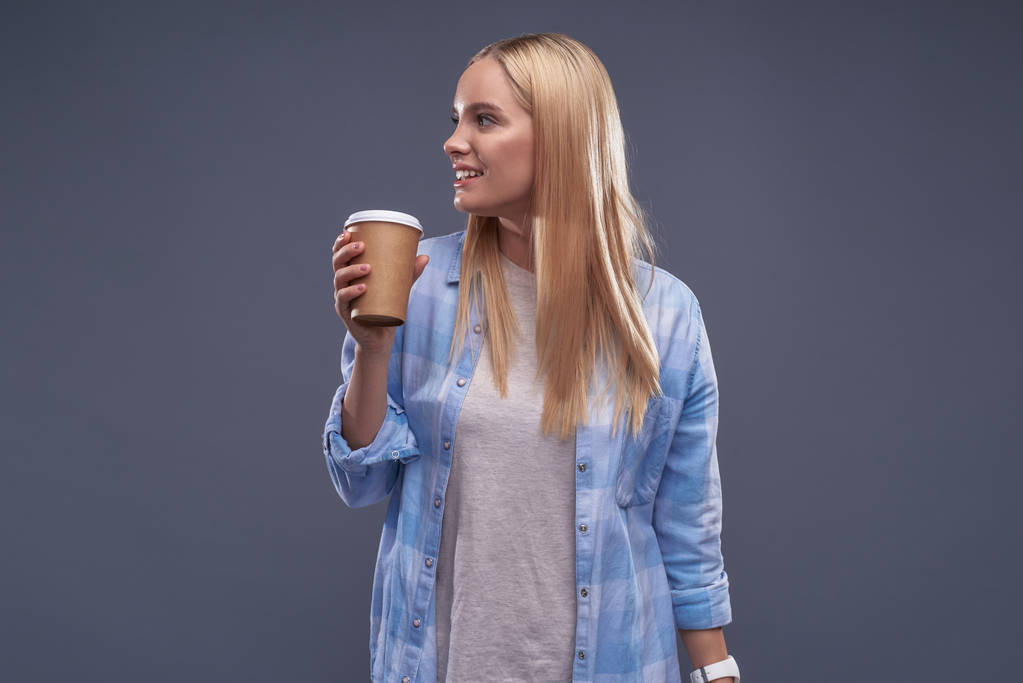 Mooi blond meisje in blauw shirt houden van kopje koffie - Foto, afbeelding