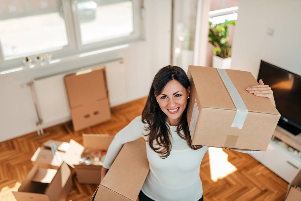 High angle image of smiling young woman moving to a new home. - Photo, Image