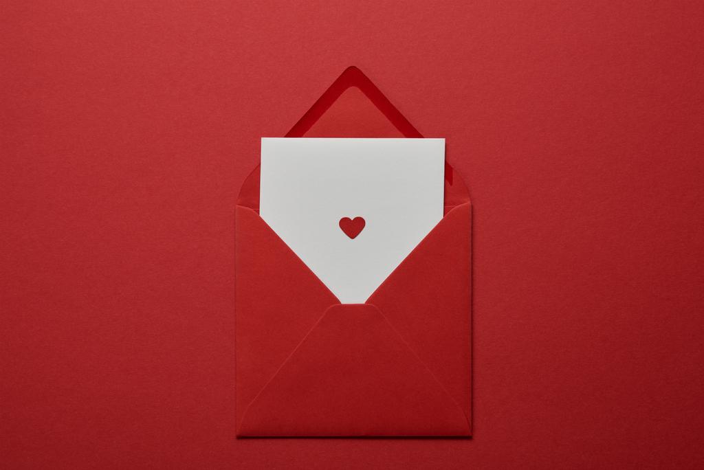 Widok z góry białe litery z sercem w kopercie na czerwonym tle - Zdjęcie, obraz