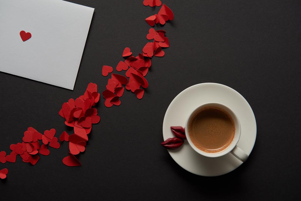 vue du haut de la carte de vœux blanche avec du papier rouge, des coeurs coupés et une tasse de café
  - Photo, image