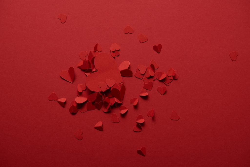 το Top view διακοσμητικό χαρτί κοπεί καρδιές σε κόκκινο φόντο - Φωτογραφία, εικόνα