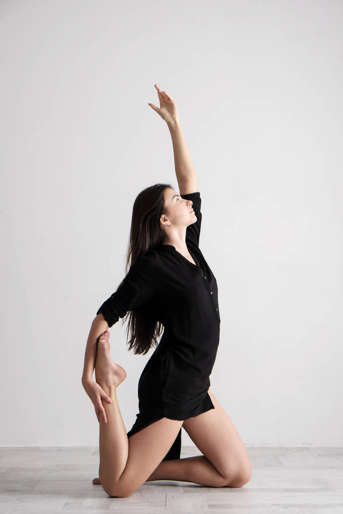 sportliche junge Frau praktiziert Yoga auf weißem Hintergrund - Konzept des gesunden Lebens und des natürlichen Gleichgewichts zwischen körperlicher und geistiger Entwicklung. - Foto, Bild