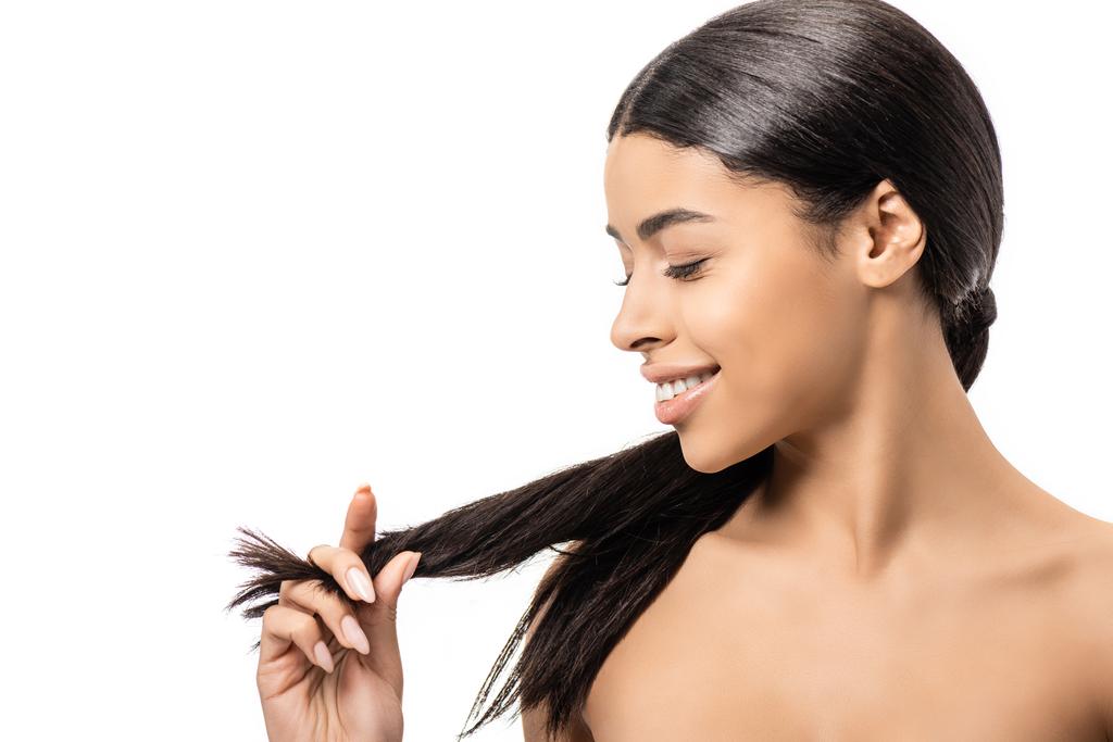 приваблива усміхнена гола афроамериканська дівчина дивиться на довге волосся брюнетки ізольовано на білому
 - Фото, зображення