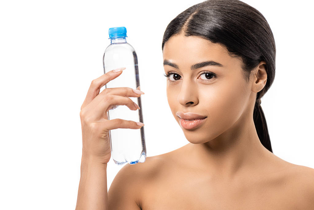 piękne nagie african american kobieta trzymając butelkę wody i patrząc na kamery na białym tle - Zdjęcie, obraz