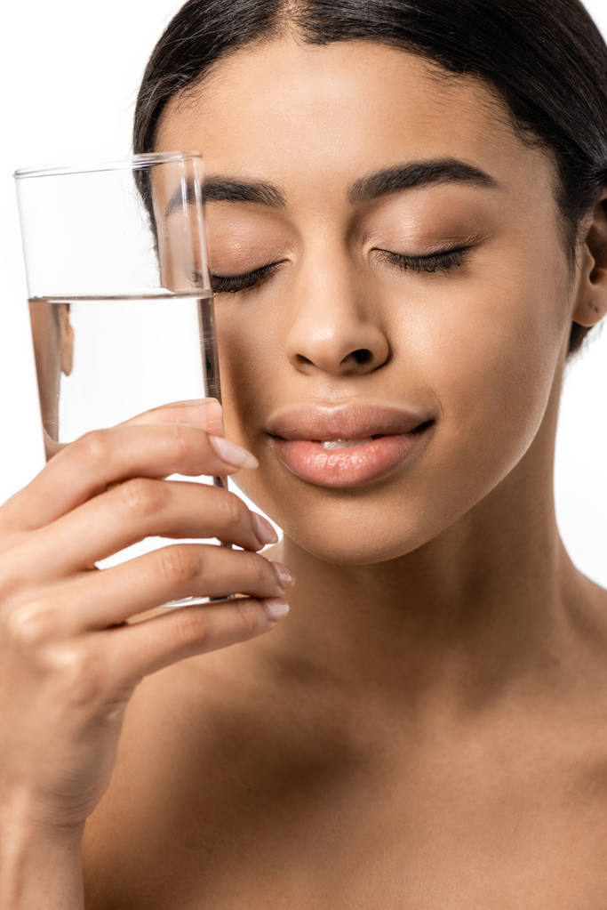 gyönyörű fiatal afrikai-amerikai nő, csukott szemmel tartja a pohár tiszta víz közelében elszigetelt fehér arc - Fotó, kép